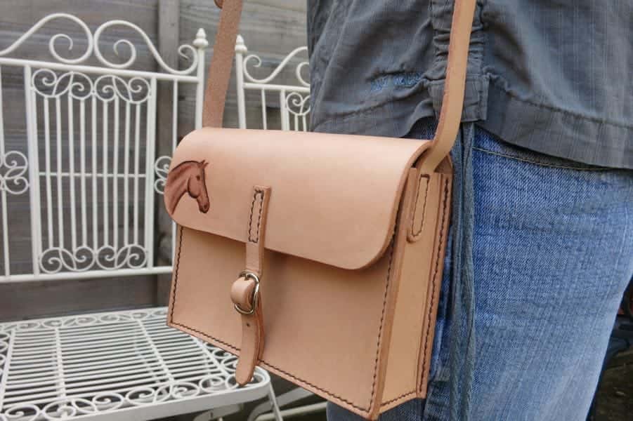 Small leather shoulder bag with horse head motif