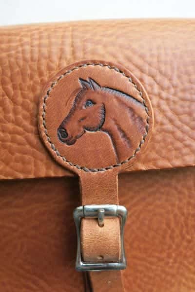 Detail of medium leather shoulder bag with horse head motif