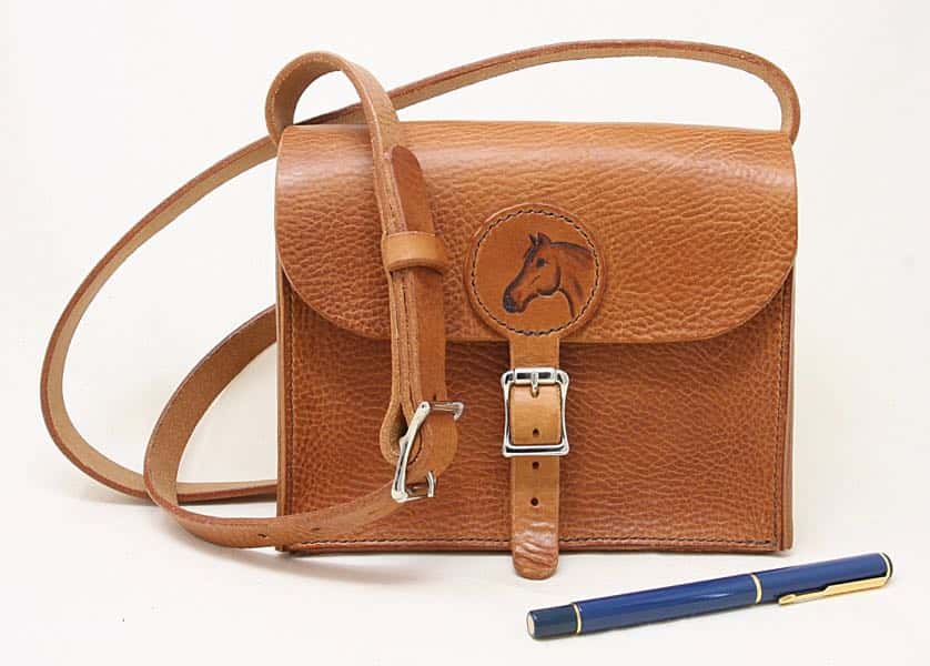 Tan brown medium leather shoulder bag with horse head motif with pen to show scale