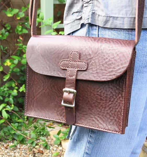 Dark brown medium leather shoulder bag with cross strap being worn