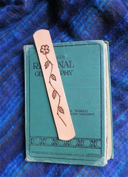 Dog rose motif leather bookmark on turquoise book