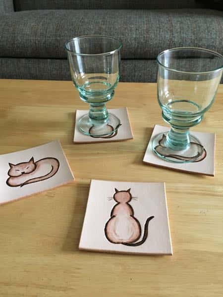 Set of cat motif square leather drinks coasters in use