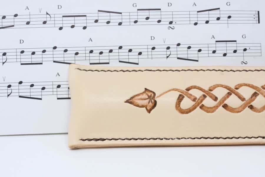 Detail of leather penny whistle case against sheet music